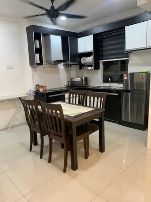 a kitchen with a table and chairs and a kitchen with black cabinets at SM Homestay @ Meru Casa Kayangan in Ipoh