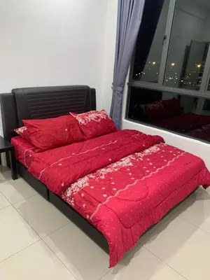 a bed with a red comforter and a window at SM Homestay @ Meru Casa Kayangan in Ipoh