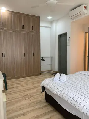 a bedroom with a bed and wooden cabinets at Barakah Homestay @ Meru Casa Kayangan in Ipoh