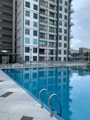 a swimming pool in front of a tall building at Barakah Homestay @ Meru Casa Kayangan in Ipoh