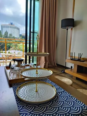 two plates on a table in a room with a balcony at Muji Homestay @ The Retreat, Cameron Highlands in Cameron Highlands