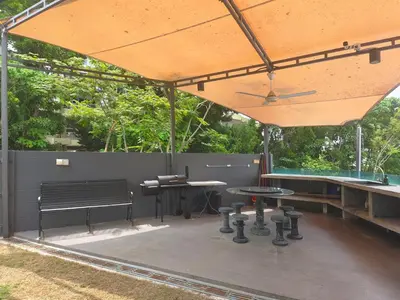 a patio with a table and benches and a umbrella at Ocean 23 Batu Ferringhi Shamrock Beach with Swimming Pool 7 Bedroom 30pax in Batu Ferringhi