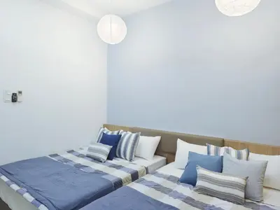 a bedroom with two beds with blue and white pillows at Ocean 23 Batu Ferringhi Shamrock Beach with Swimming Pool 7 Bedroom 30pax in Batu Ferringhi