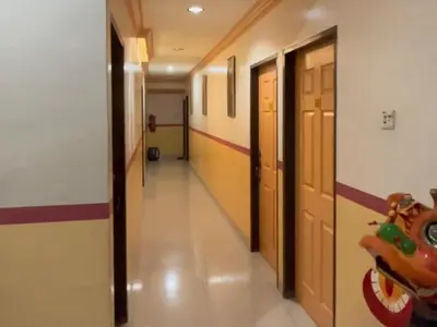 a hallway in a school with doors and a hallway at Hotel Langkap LW \u51b7\u7532\u9152\u5e97 in Kampung Degong