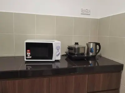 a microwave sitting on top of a kitchen counter at Emerald Avenue Cozy 3R3B Apartment - 329 in Brinchang
