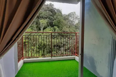 a balcony with green flooring and a view of trees at Emerald Avenue Cozy 3R3B Apartment - 329 in Brinchang