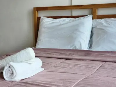 a bed with white pillows and towels on it at The MINDI, 2BR Cityview by WStay @ Tropicana 218 Macalister in George Town