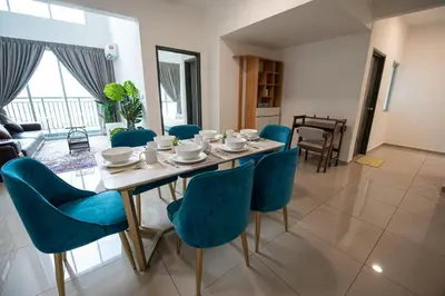 a dining room with a table and blue chairs at De Luma-Metropol in Bukit Mertajam