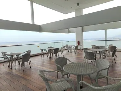 a dining room with tables and chairs and windows at Gurney Duplex / 2bedrooms / 8pax in George Town
