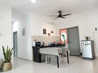 a kitchen with a table and a refrigerator at Cosy Apartment Ipoh Town - WiFi Netflix FREE in Ipoh