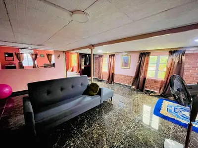a living room with a couch and a dog laying on it at Halim's Rumah Singgah Mxslim only in Jelutong