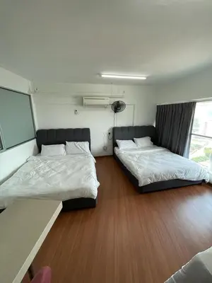 two beds in a room with wood flooring in a room at 4PAX near USM n Pantai Hospital n PISA SPI CE ARENA in Bayan Lepas