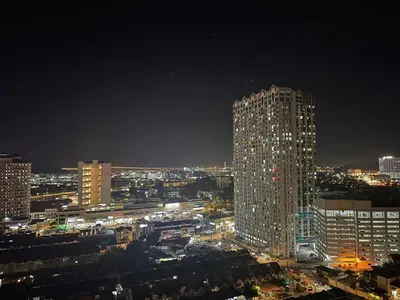 a night view of a city with a tall building at 6PAX NEAR USM n PANTAI HOSPITAL n SPI CE ARENA in Bayan Lepas