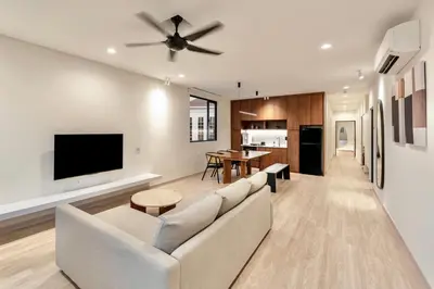 a living room with a white couch and a flat screen tv at Codrington House - Boutique Apartments in George Town