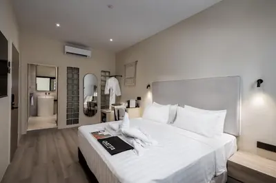 a bedroom with a large white bed and a bathroom at Muntri Maison in George Town