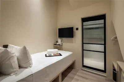 a hotel room with a bed and a television at Muntri Maison in George Town