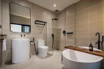 a bathroom with a tub and a toilet and a sink at Muntri Maison in George Town