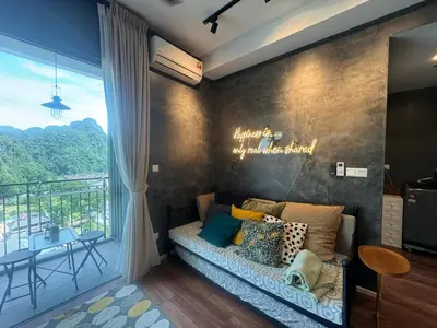 a living room with a couch and a large window at Ipoh Sunway Onsen Suites and Tambun Guesthouse , 3-14pax 2parking by IWH in Ipoh