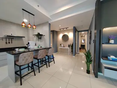 a kitchen with a counter and chairs in a room at Ipoh Sunway Onsen Suites and Tambun Guesthouse , 3-14pax 2parking by IWH in Ipoh