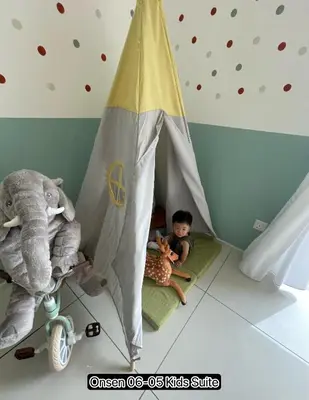 a child sitting in a tent in a room with stuffed animals at Ipoh Sunway Onsen Suites and Tambun Guesthouse , 3-14pax 2parking by IWH in Ipoh