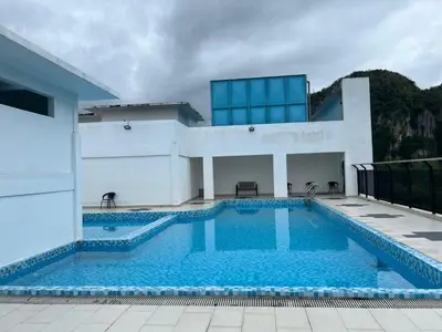 a swimming pool in front of a house at SAMSARA Studio Apartment at Kompleks Mutiara GM in Gua Musang