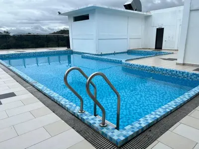 a large swimming pool with two handles in the water at SAMSARA Studio Apartment at Kompleks Mutiara GM in Gua Musang