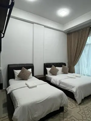 two beds in a room with white sheets and a window at HASSMA Studio Apartment at Kompleks Mutiara GM in Gua Musang