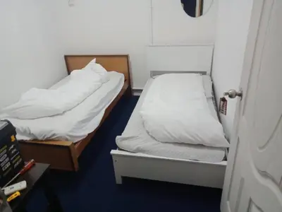 a bedroom with two beds with white sheets at 246housecafe in George Town