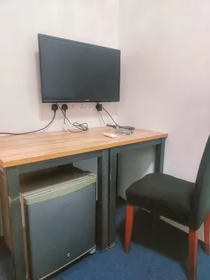 a desk with a computer monitor and a chair at 246housecafe in George Town