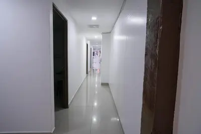 a hallway with white walls and a long white tile floor at Heritage Inn in George Town