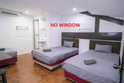 two beds in a room with a no window sign on the wall at Heritage Inn in George Town