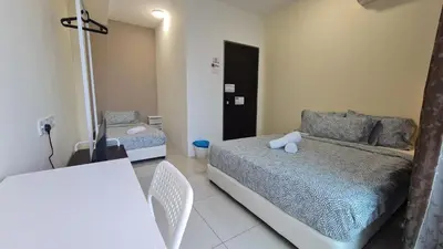 a bedroom with a bed and a table and chairs at Rooms at Mansion One, Shared Apartment Only in George Town