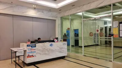 a person sitting at a desk in a lobby at Rooms at Mansion One, Shared Apartment Only in George Town