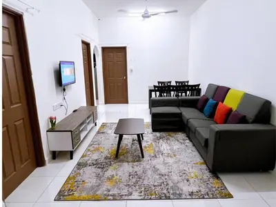 a living room with a couch and a tv at HomeSTAY PANGSAPURI SAMUDERA SERI MANJUNG LUMUT in Seri Manjung