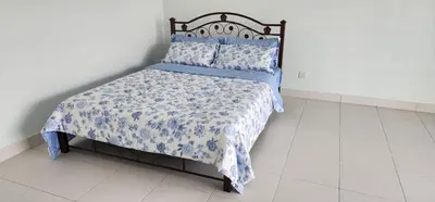 a bed with a blue and white blanket and pillows at Bertam Homestay Kepala Batas in Kepala Batas