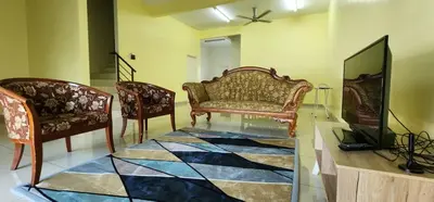 a living room with two chairs and a couch and a television at Bertam Homestay Kepala Batas in Kepala Batas