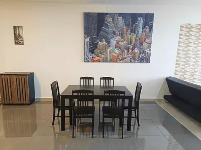 a dining room table with chairs and a painting on the wall at Freezing Point Homestay @ Palas Horizon Residence in Cameron Highlands