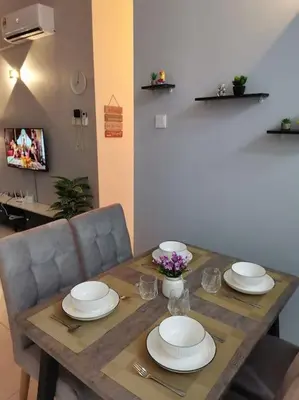 a wooden table with plates and flowers on it at Casa Apartment @ Ipoh \u3010\u6021\u4fdd\u6c11\u5bbf\u3011 in Ipoh