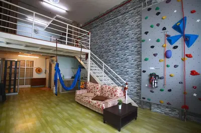 a living room with a climbing wall and a couch at Private Rock Climb at The CEO Penang in Bayan Lepas