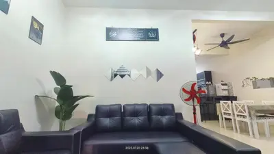 a living room with a leather couch and a table at Syaurah Homestay Bagan Serai Dua Tingkat 4 Bilik in Bagan Serai