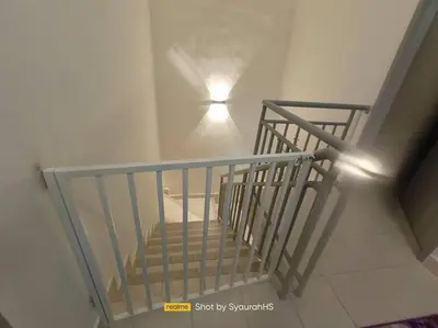 a staircase with a light on the wall and a light on the ceiling at Syaurah Homestay Bagan Serai Dua Tingkat 4 Bilik in Bagan Serai