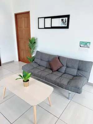 a living room with a couch and a table at Ipoh Town - Octagon Cozy Deluxe Homestay in Ipoh