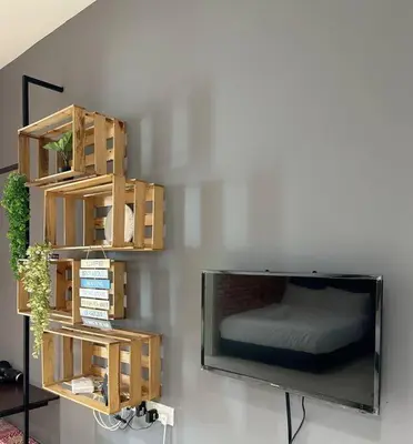 a bedroom with a tv and a bed on a wall at Ipoh Town - Octagon Cozy Deluxe Homestay in Ipoh