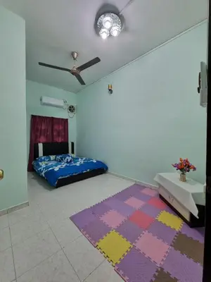 a bedroom with a bed and a rug on the floor at HELLO HOMESTAY in Nibung Tebal