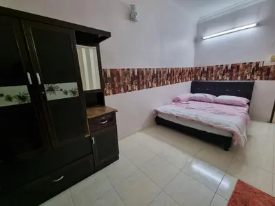 a small bedroom with a bed and a dresser at HELLO HOMESTAY in Nibung Tebal