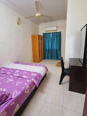 a bedroom with a purple bed and a desk at HELLO HOMESTAY in Nibung Tebal