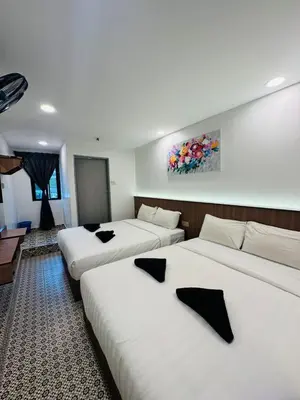 a hotel room with three beds with black crosses on them at Ar Rayyan Hotel in Tanah Rata