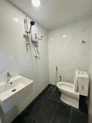 a white bathroom with a sink and a toilet at Ar Rayyan Hotel in Tanah Rata