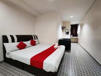 a bedroom with a large bed with red pillows at Ar Rayyan Hotel in Tanah Rata
