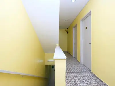 a hallway with yellow and white walls and a white bench at Ar Rayyan Hotel in Tanah Rata